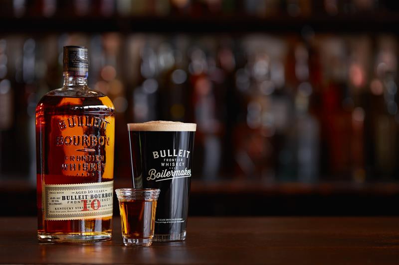 Een bulleit bourbonfles, een scheut whisky en een pint bier