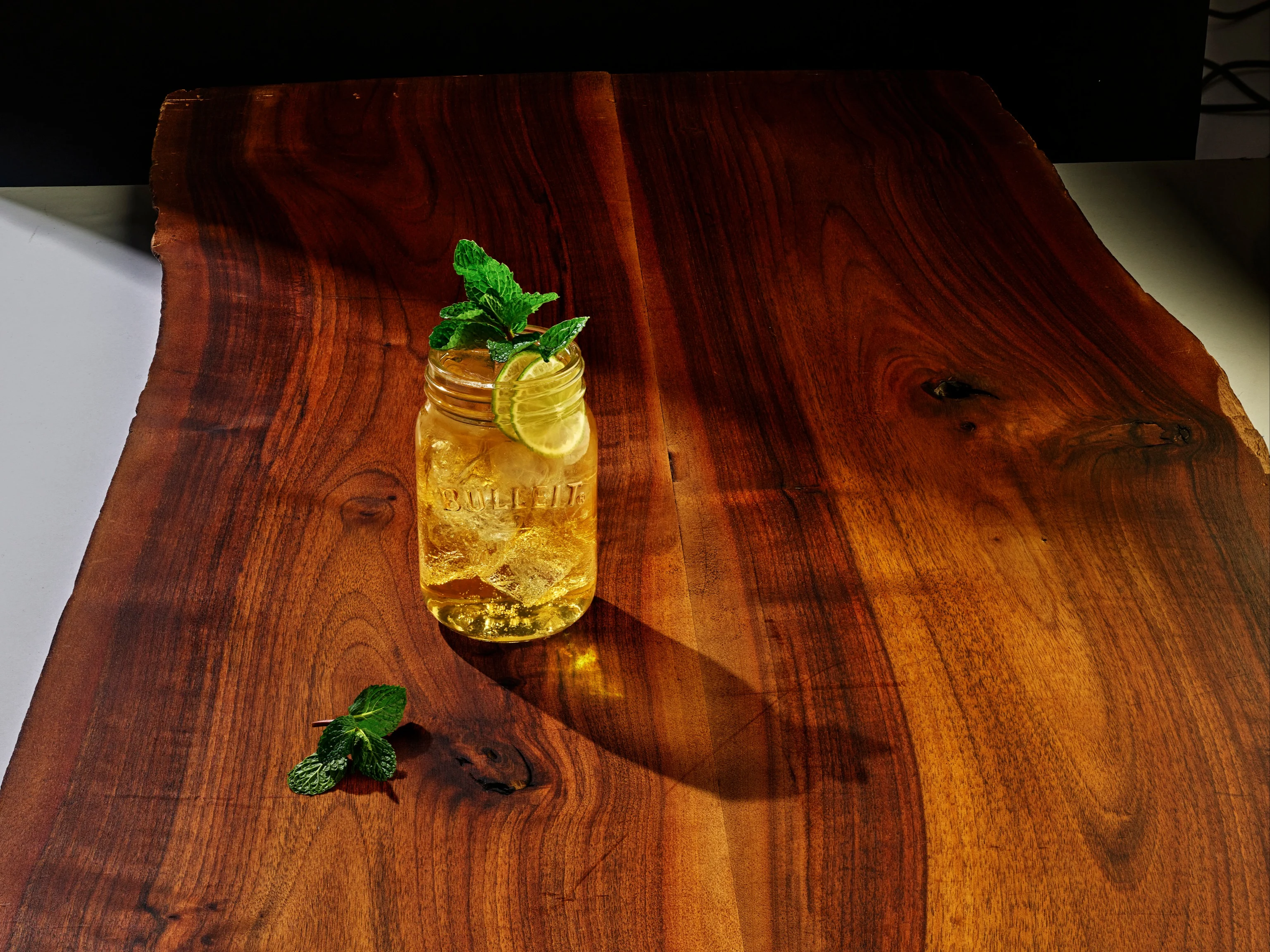 Kentucky-Mule-Cocktail in einem Mason-Glas auf einem Holztisch.