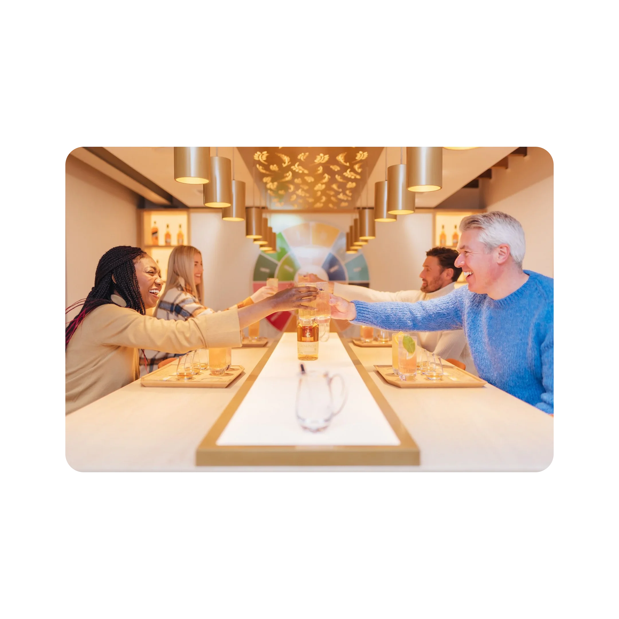 A smiling group toast Glenkinchie's finest over a well lit dining table.
