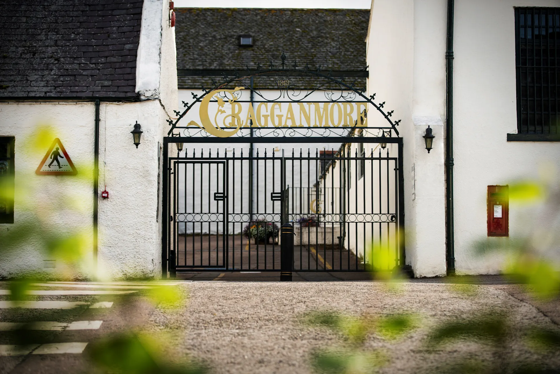 Outside view of the distillery gate where you can see written Cragganmore in gold 