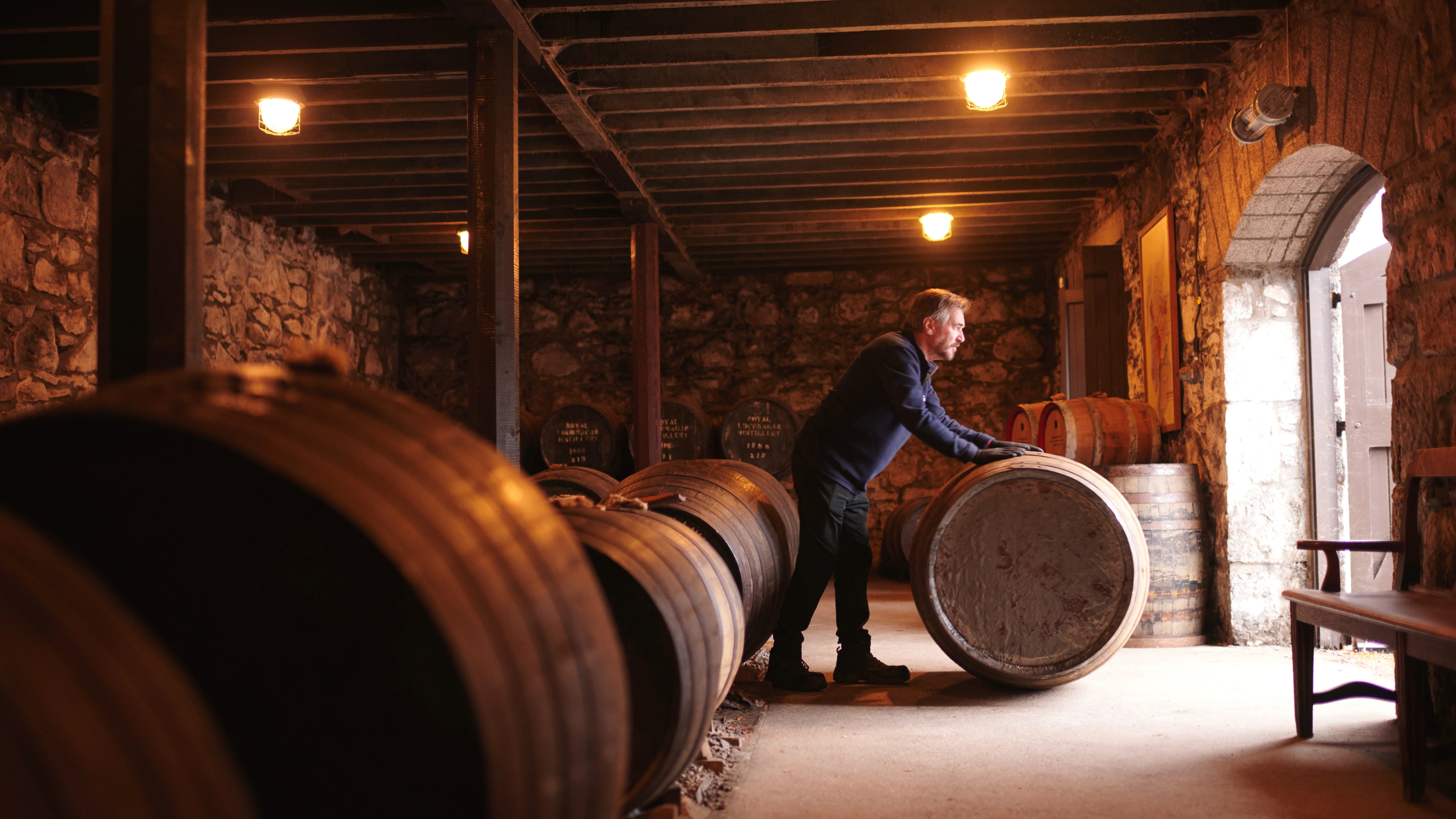 A man rolls a whisky barrel