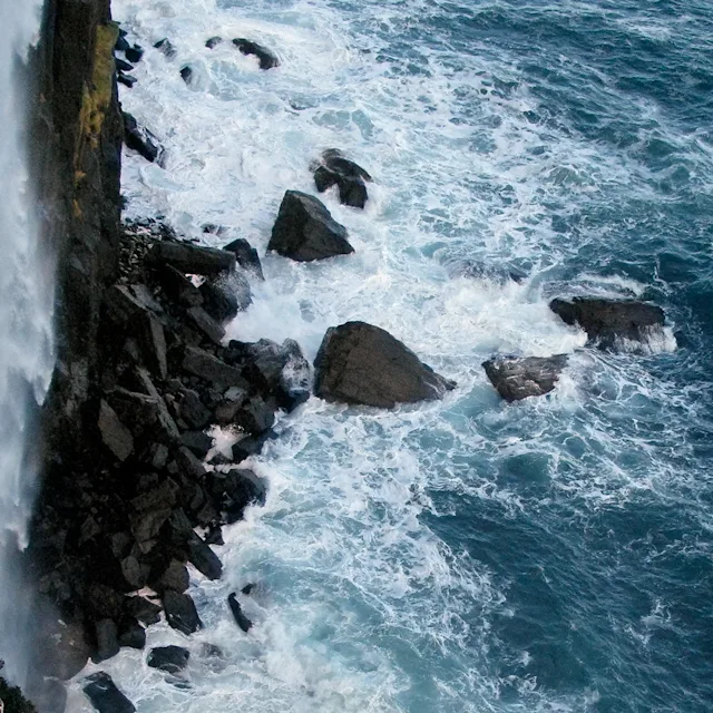 Uitzicht op de klif met oceaangolven die tegen de rotsen slaan