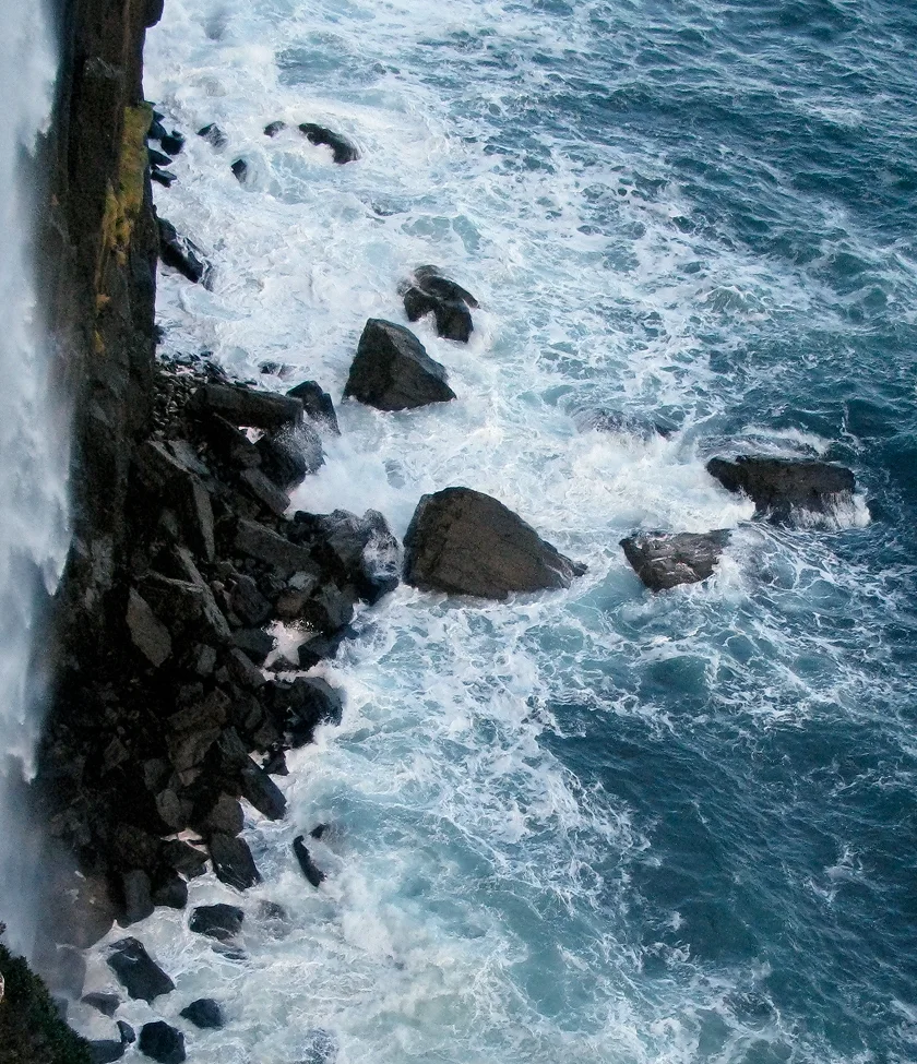 Cliffside view with ocean waves crashing against the rocks