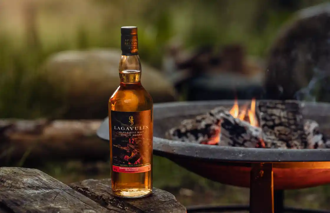 Lagavulin Fireside Tales bottle outside by a campfire 