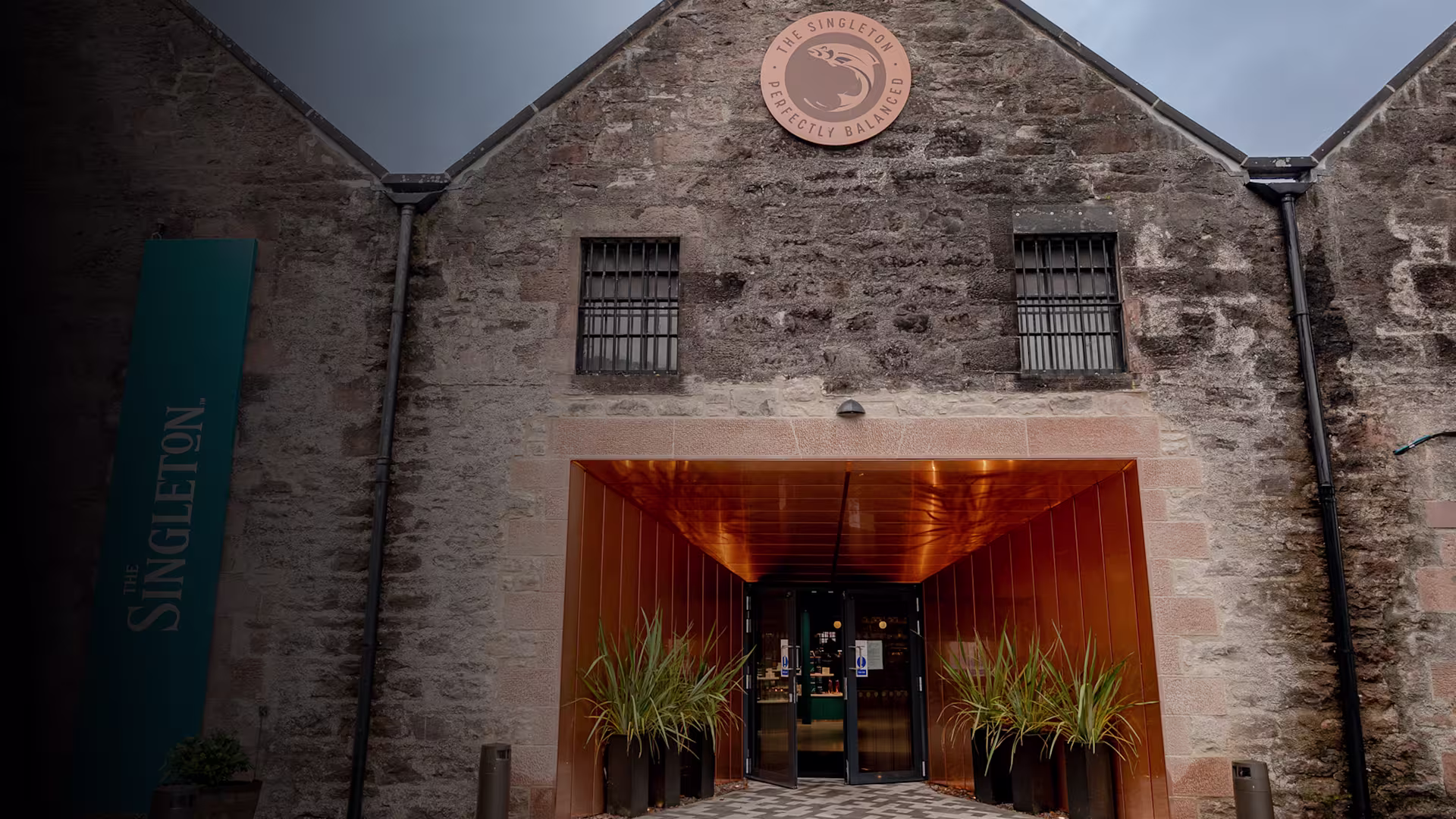 Entrance to Glen Ord Distillery with copper accents and The Singleton logo above the doorway.
