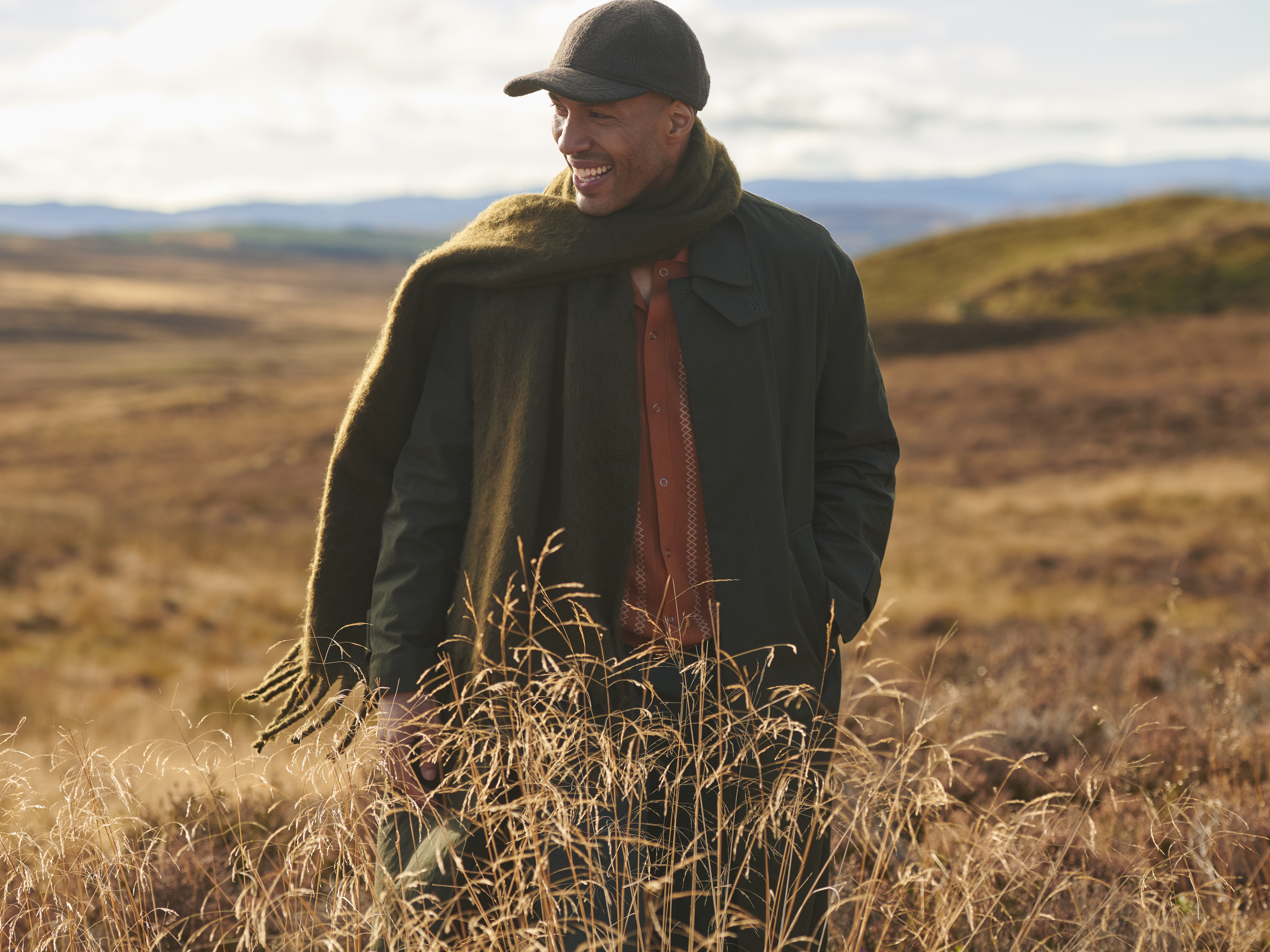 A man stand on a Highland hill, looking out into the distance