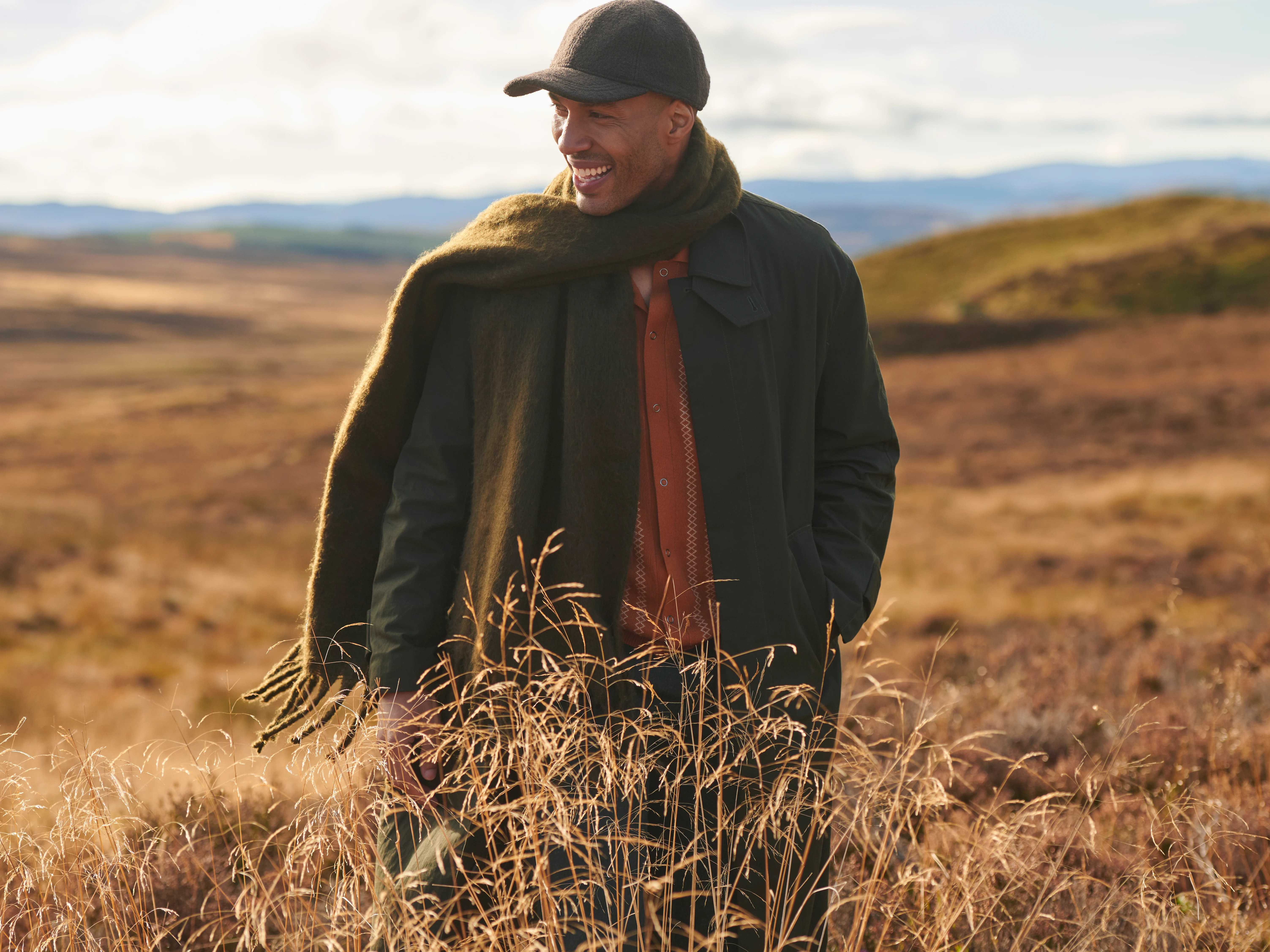 A man stand on a Highland hill, looking out into the distance