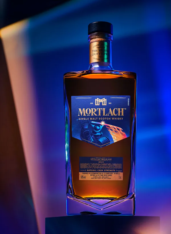 Een fles Mortlach single malt Scotch whisky staat op een sokkel voor een gouden en blauwe achtergrond.