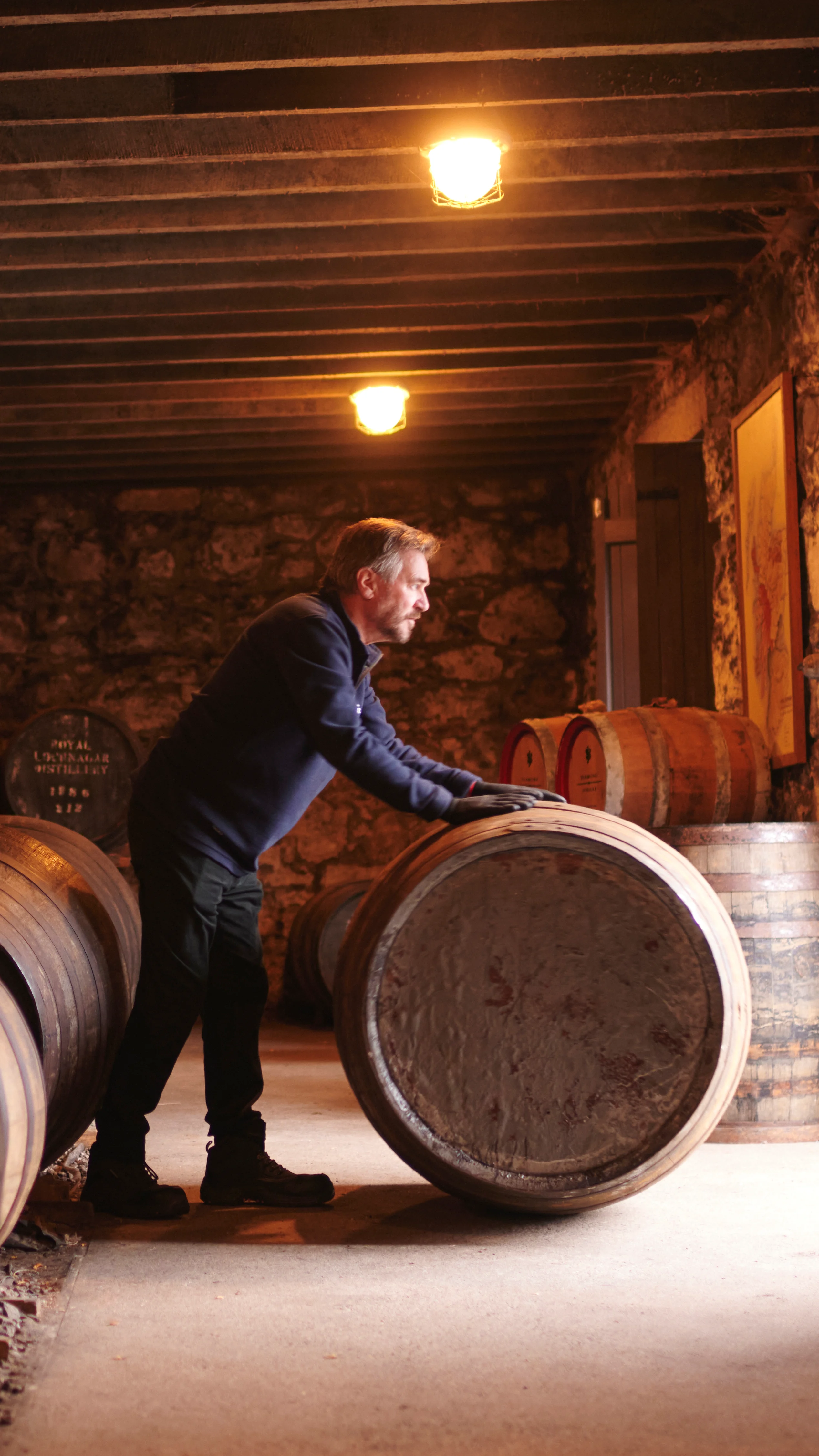A man rolls a whisky barrel