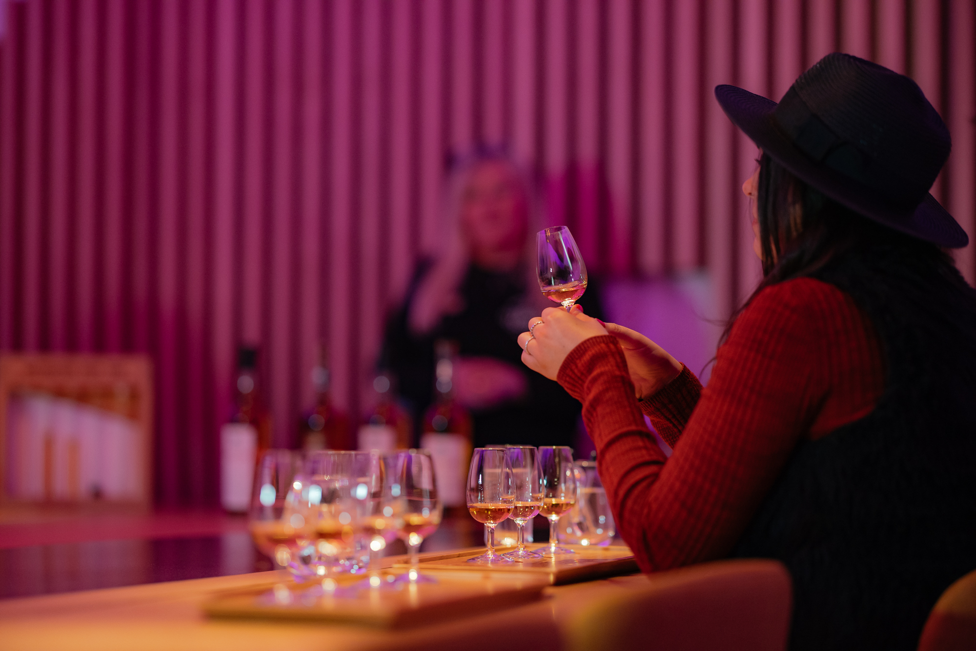 Women taking part of the tasting experience holding a small glass of whisky