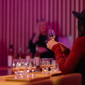 Women taking part of the tasting experience holding a small glass of whisky