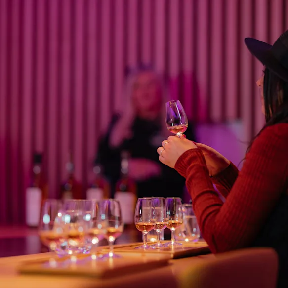 Women taking part of the tasting experience holding a small glass of whisky