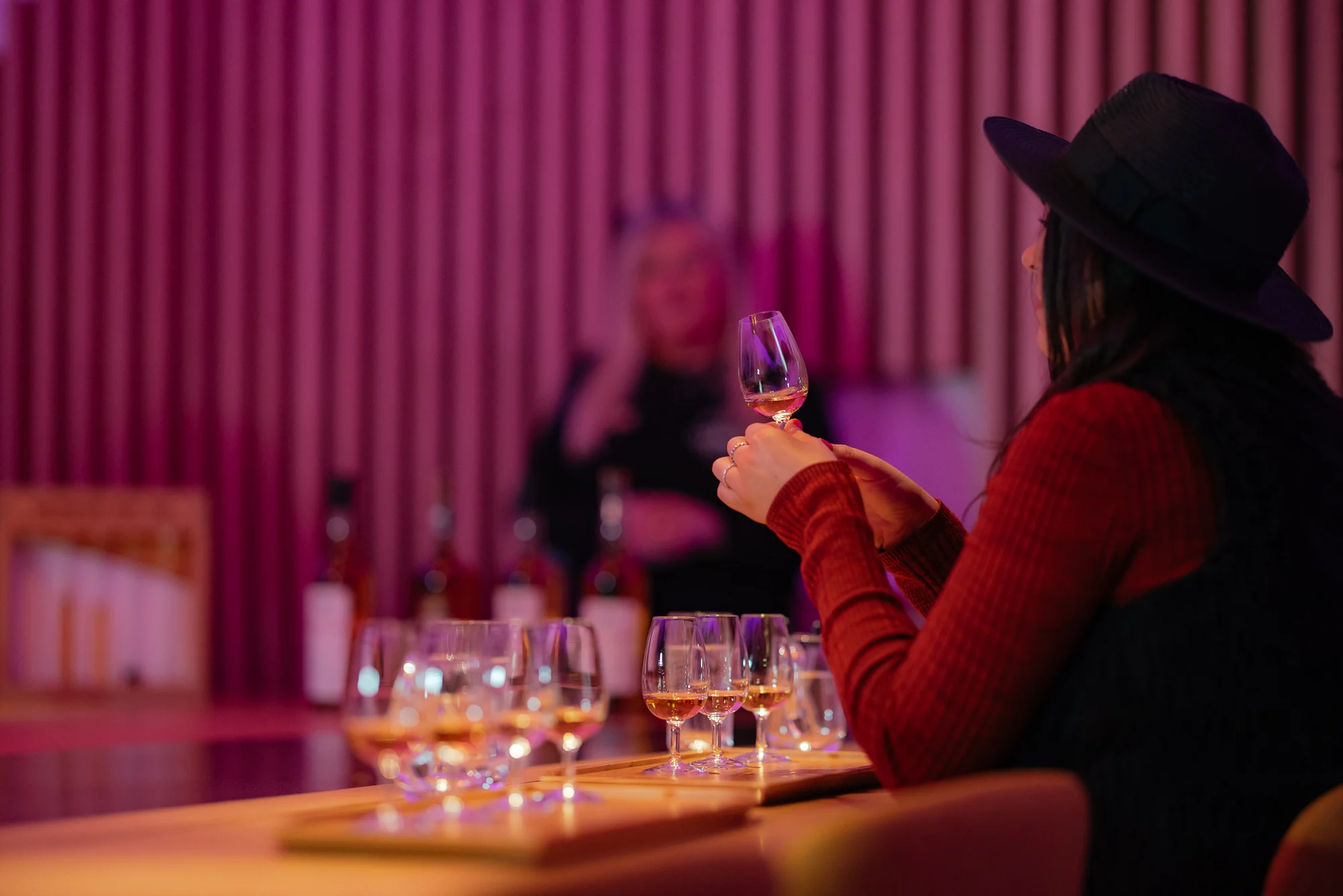 Women taking part of the tasting experience holding a small glass of whisky
