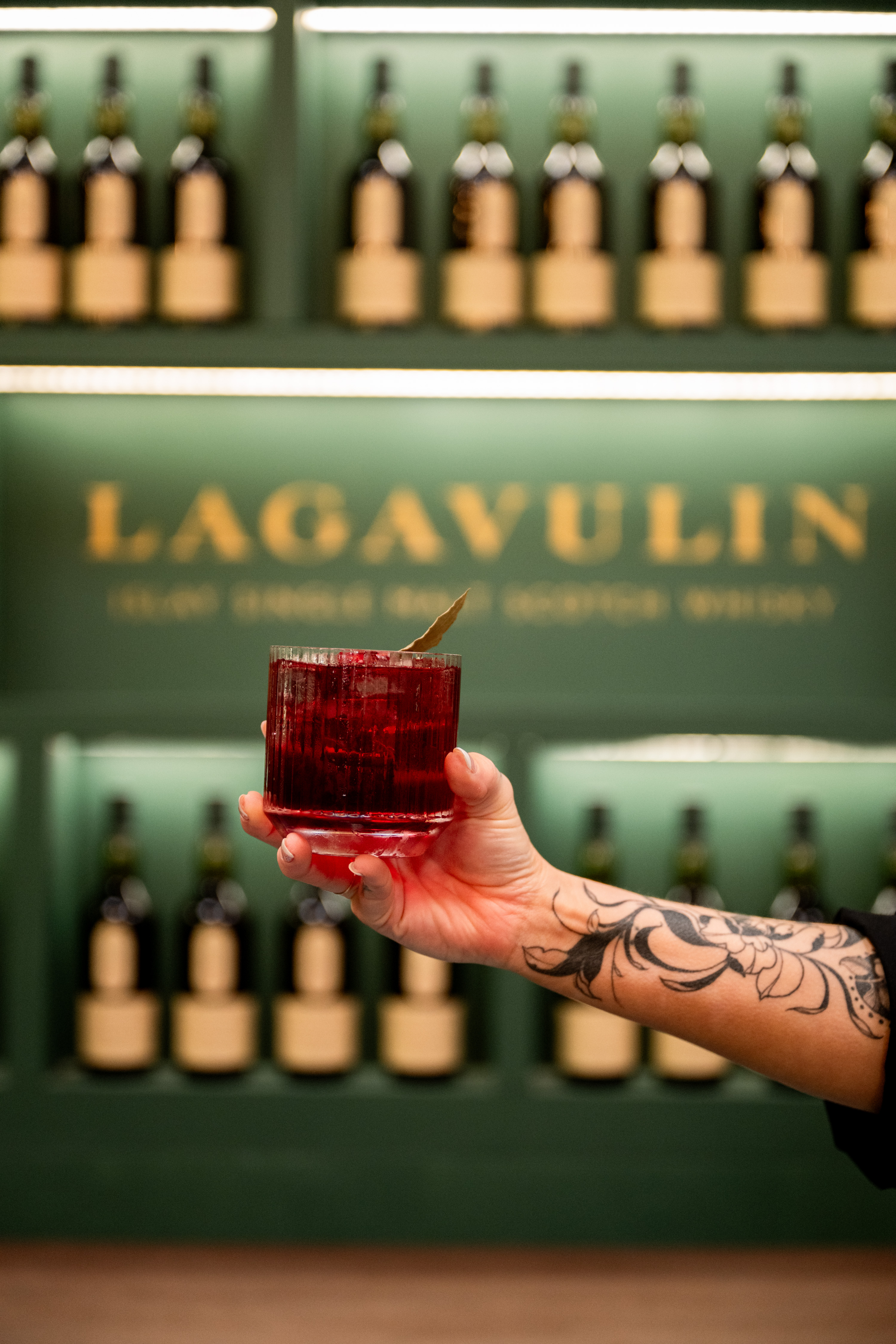 Explore our recipes Lagavulin whisky cocktail in red glass held in bar setting