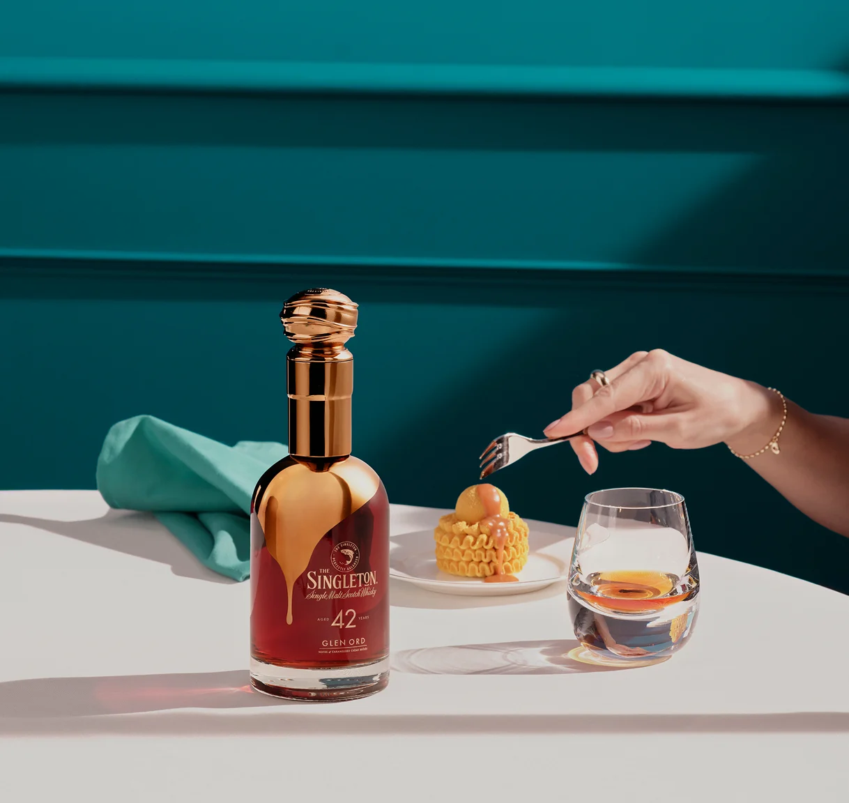  De Singleton fles met een dessert en een glas whisky, met de nadruk op tonen van gekarameliseerde crème brûlée.