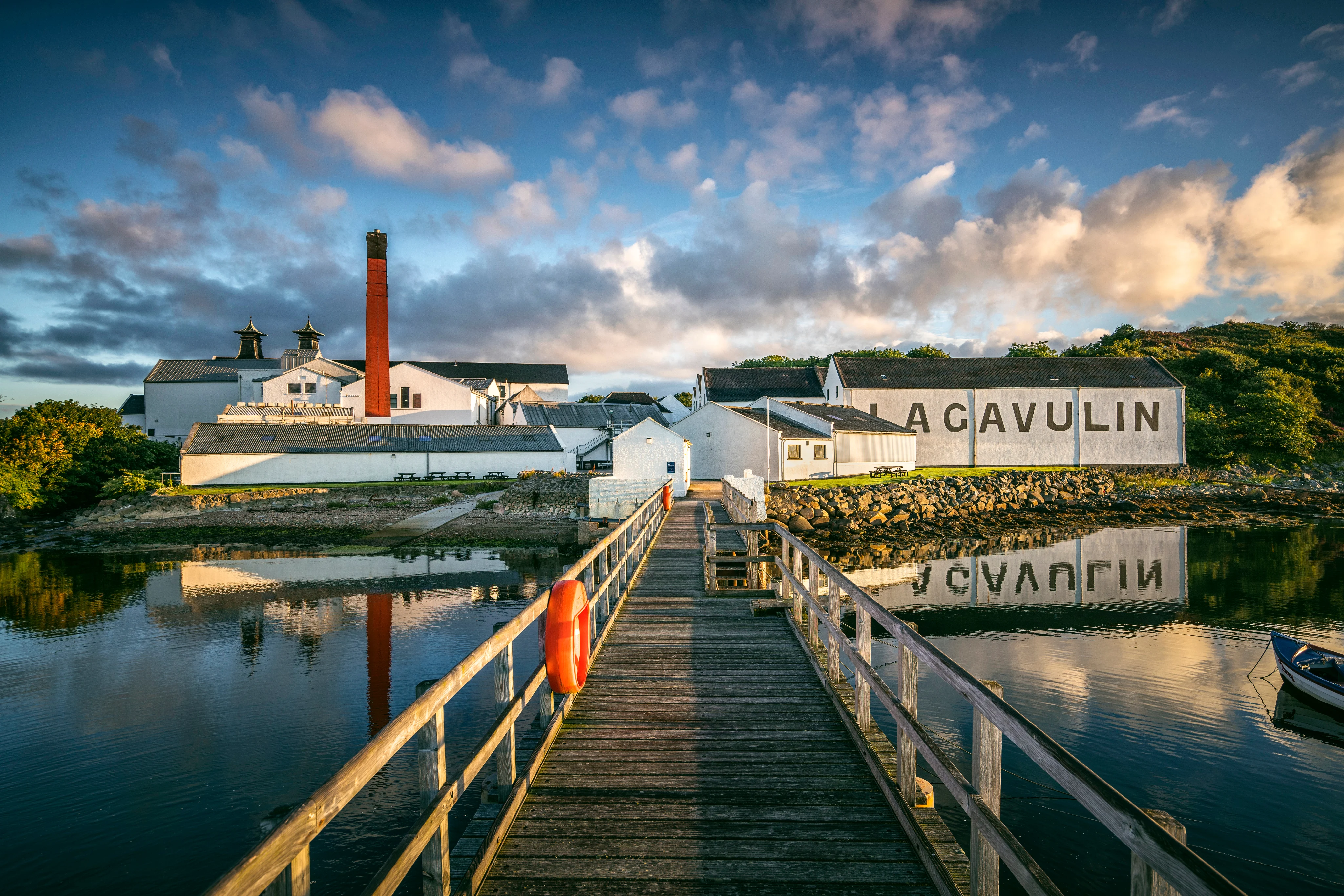 Aerial view of Lagavulin distillery on the Isle of Islay with its distinctive white-washed buildings and pagoda rooftop set against the Scottish coastline