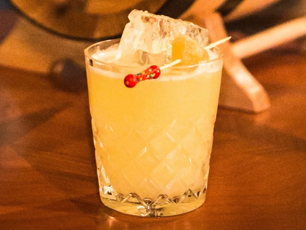 Ein Penicillin-Cocktail in einem Eisglas mit kandiertem Ingwer als Garnitur.