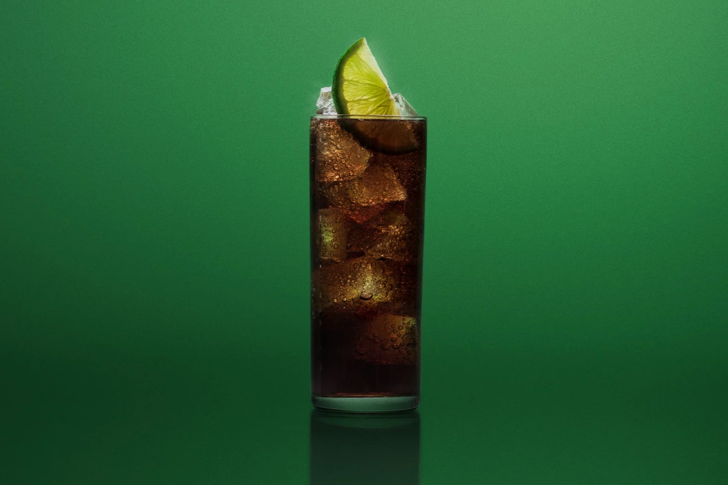 Twee whisky en cola in highballglazen, afgetopt met een partje limoen, naast een bodempje Lagavulin.