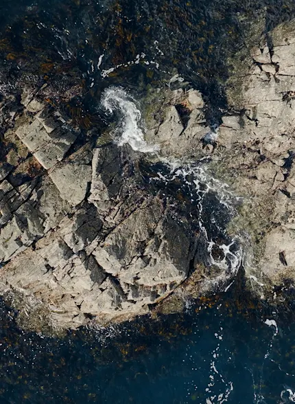 Meereswellen, die sanft gegen zerklüftete Felsen schlagen
