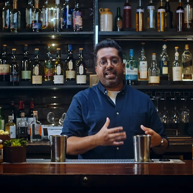 Mr Lyan stands behind a bar