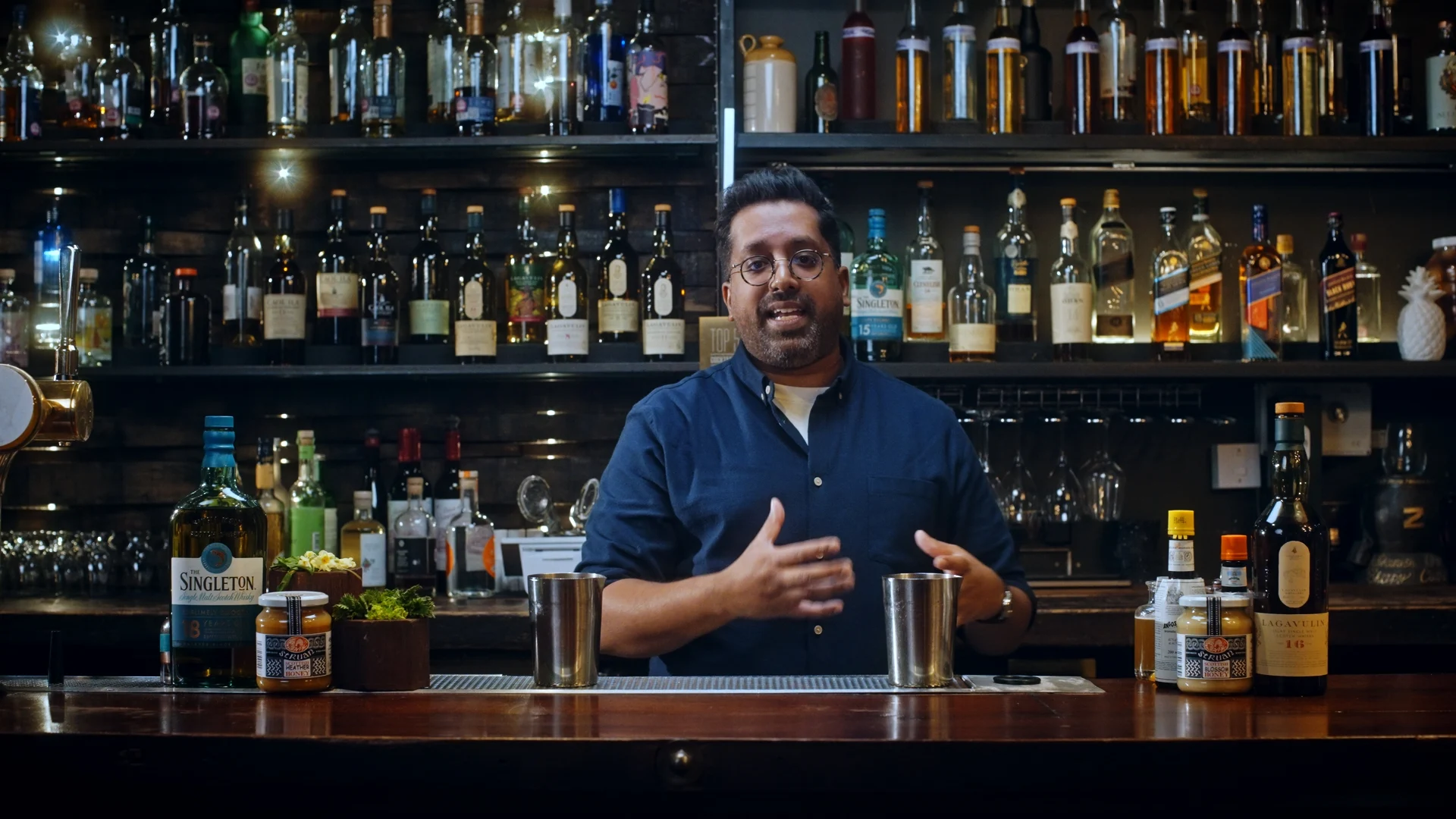 Mr Lyan stands behind a bar