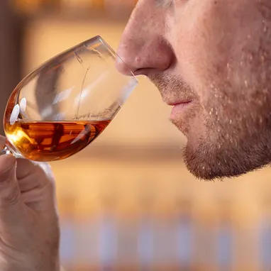 A close up portrait of Dr Craig Wilson Master Blender, nosing a glass of whisky