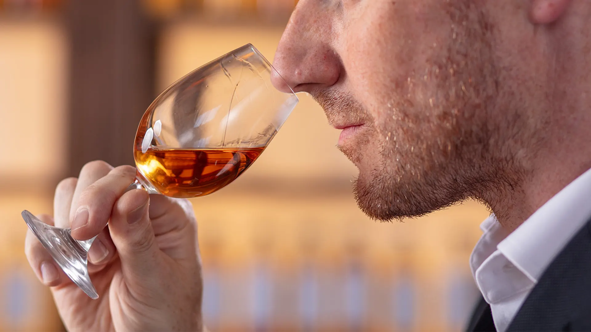A close up portrait of Dr Craig Wilson Master Blender, nosing a glass of whisky