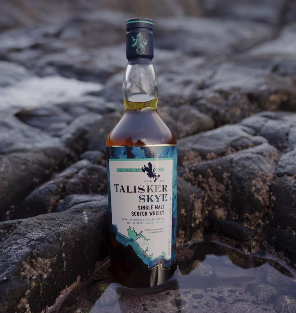 a bottle of talisker on a stone beach