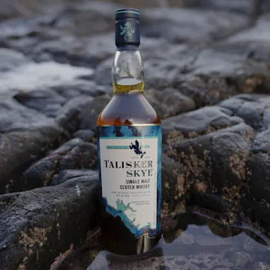 een fles talisker op een stenen strand