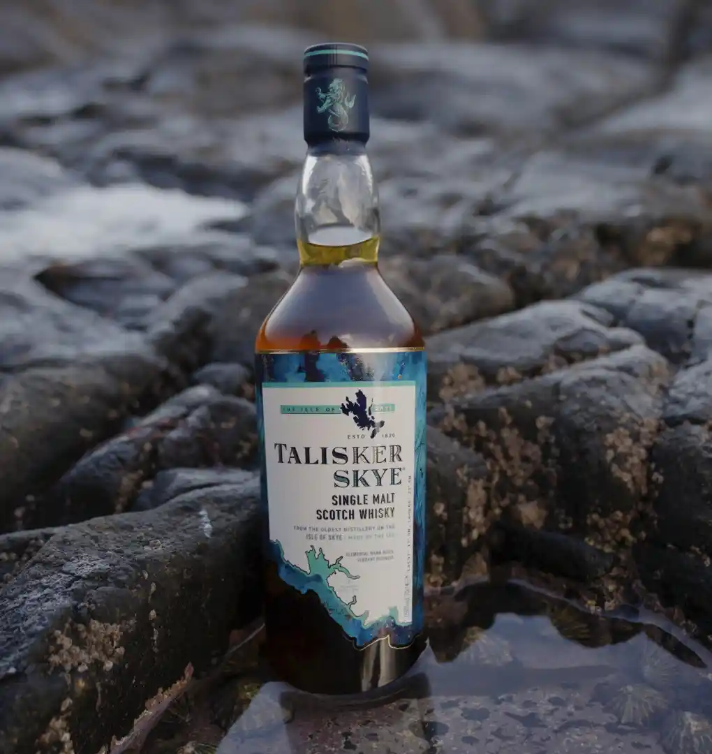 a bottle of talisker on a stone beach