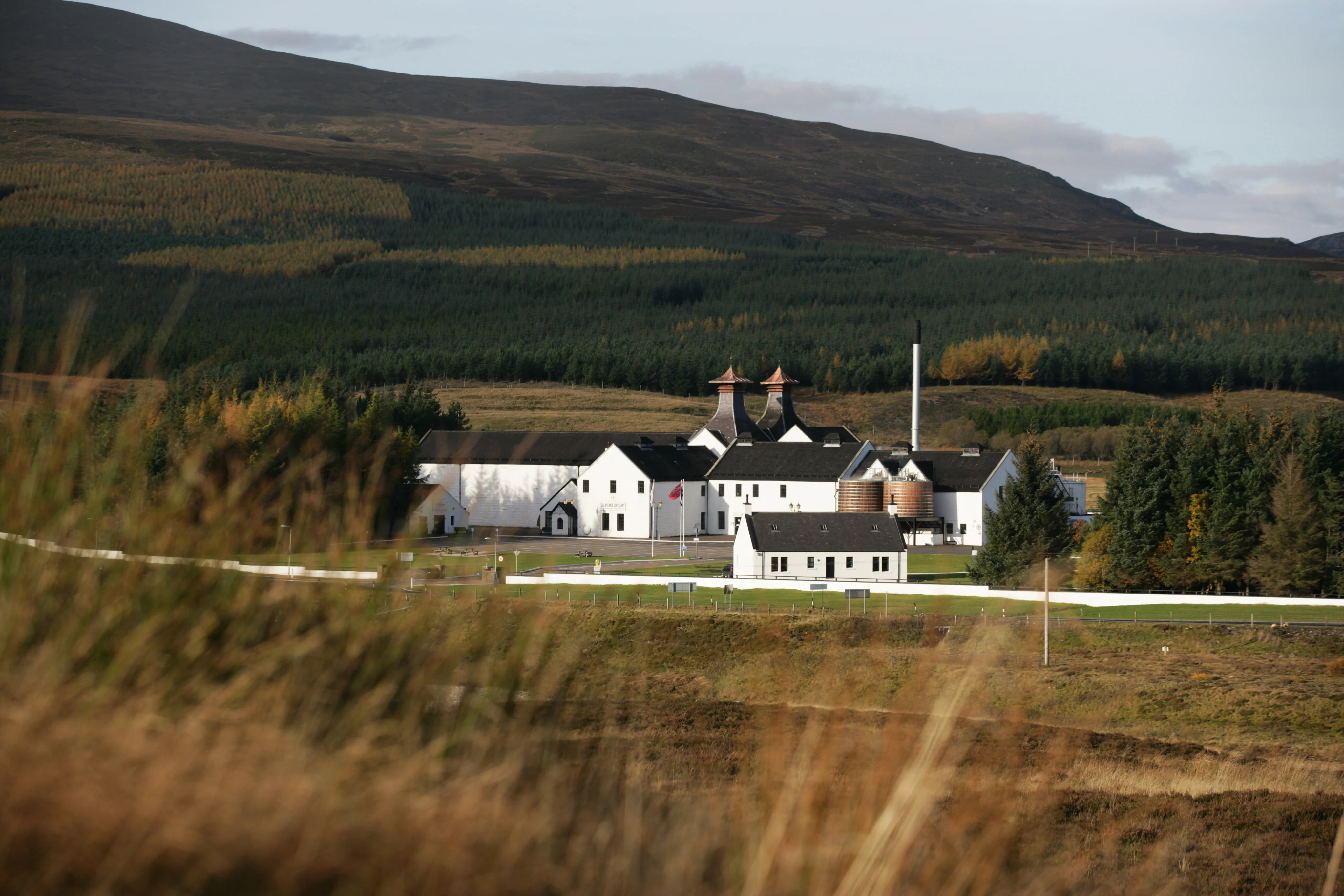 Dalwhinnie distillery in the Scottish Highlands surrounded by mountain landscape