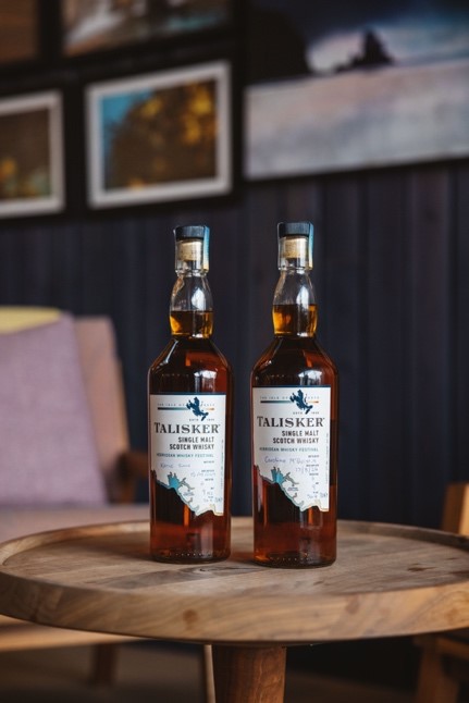 Two bottles of Talisker sit on a wooden table