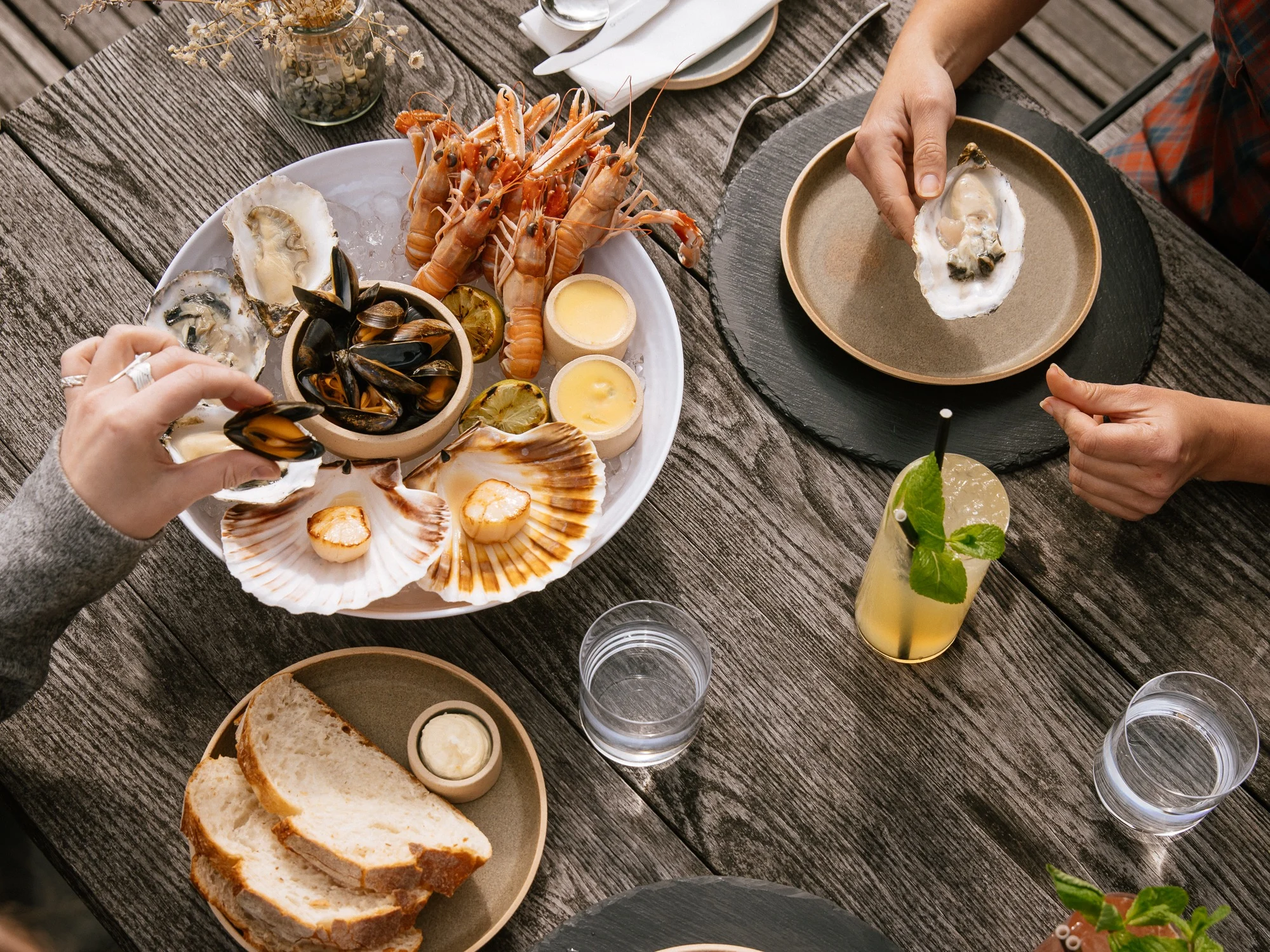 Assorted plates of seafood and whisky cocktails.