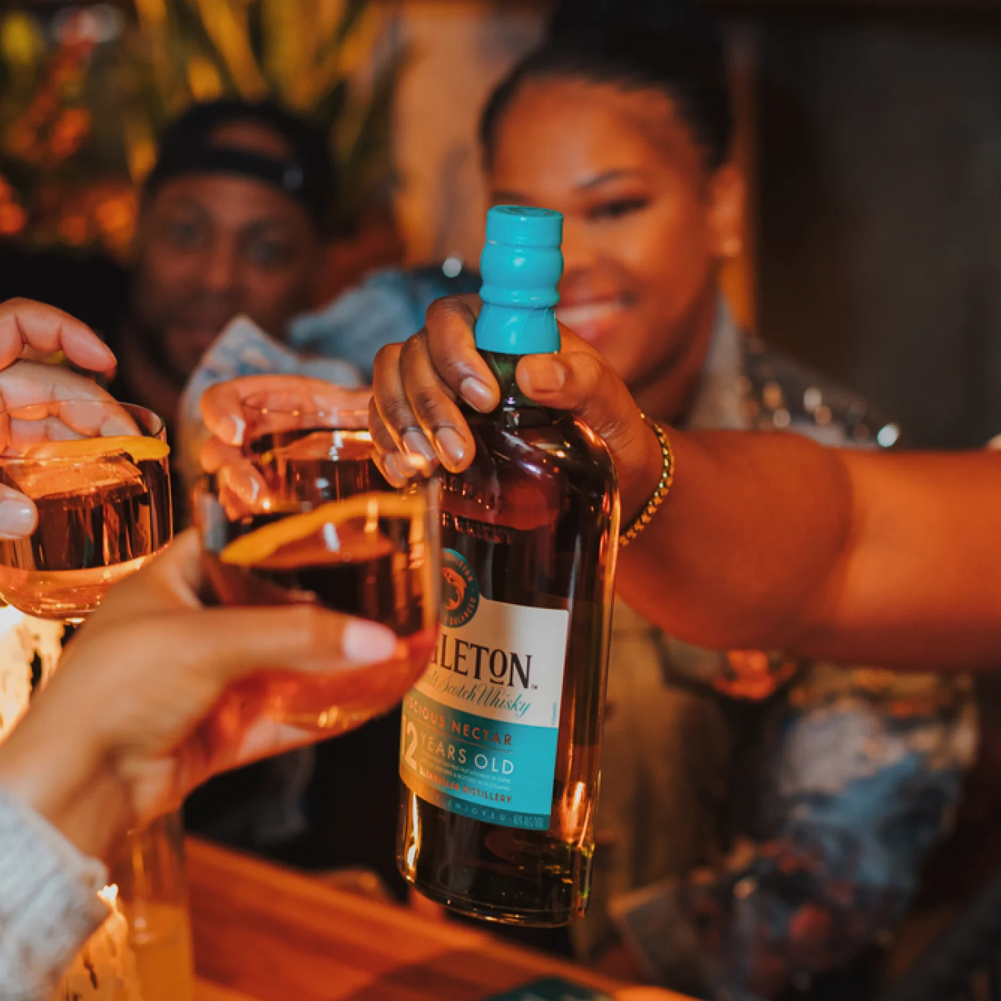 Group toasting with The Singleton of Dufftown 12 Year Old bottle and whiskey glasses