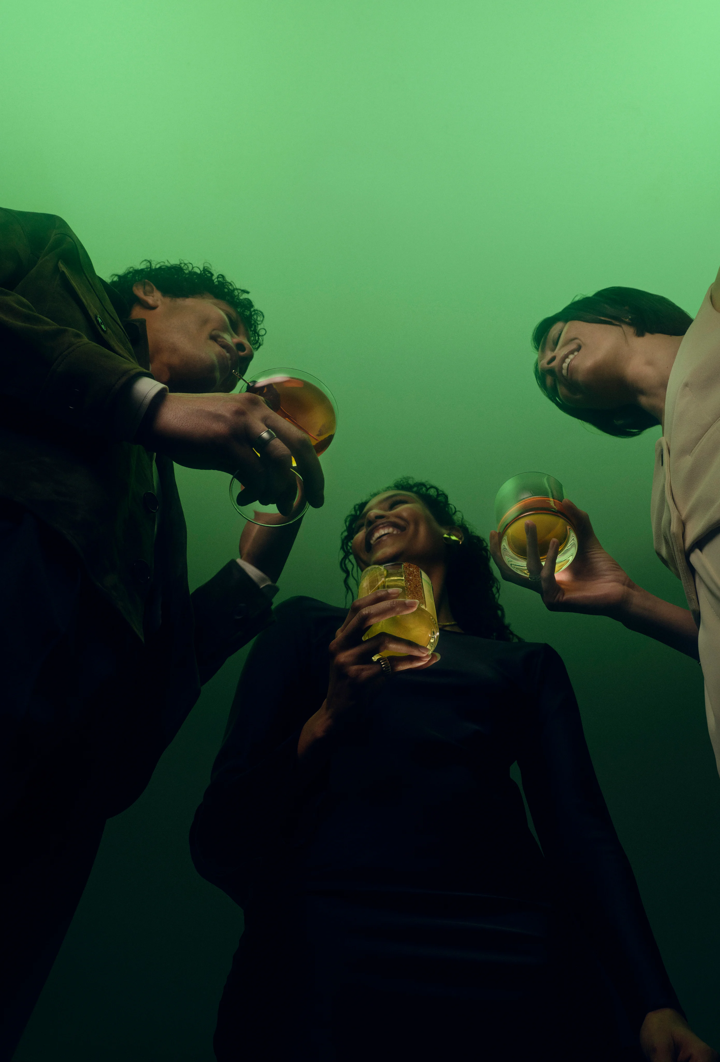 Three people enjoying Lagavulin cocktails in green lighting