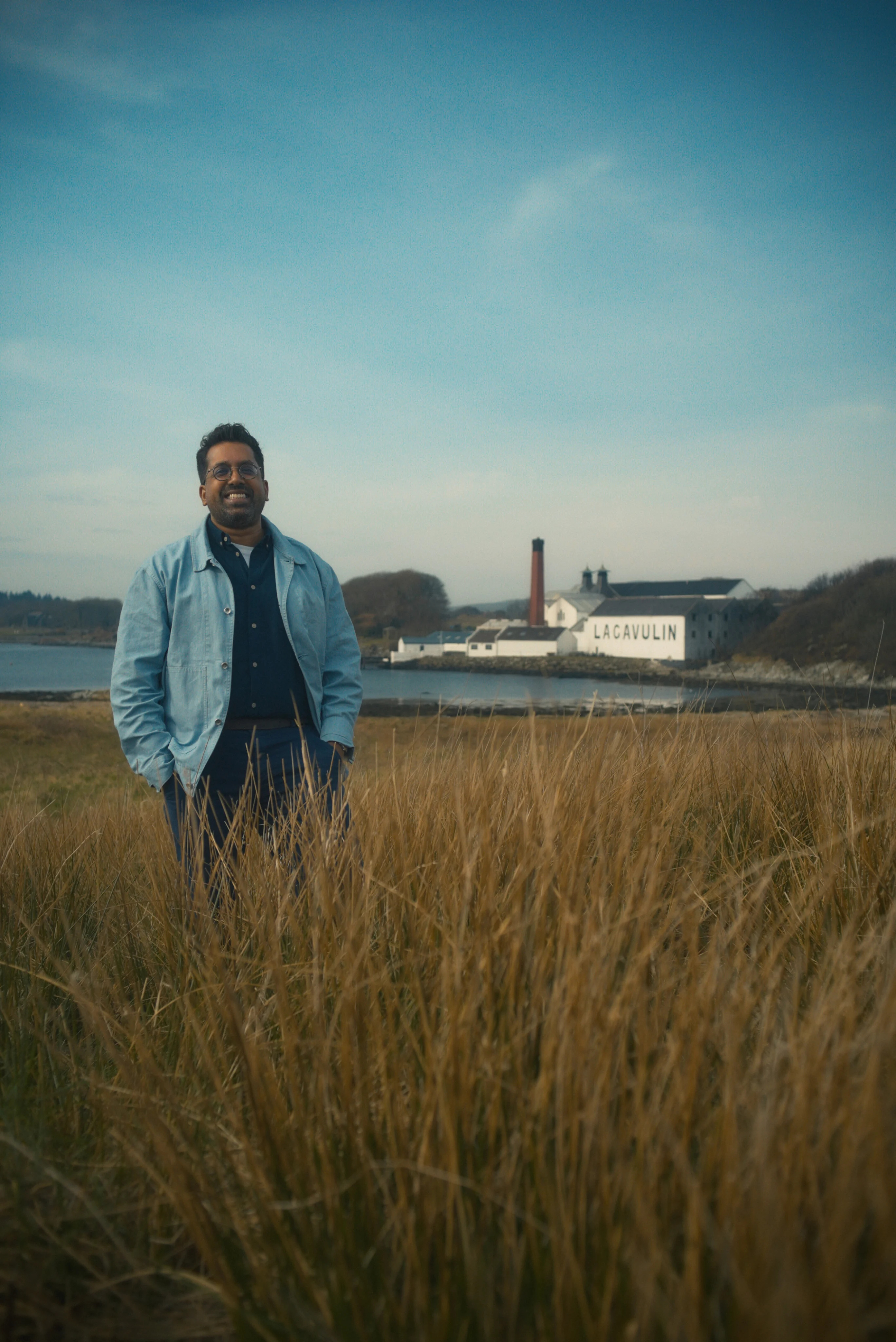 Ryan Chetiyawardana, Mr Lyan, standing in the fields by the Lagavulin distillery on Islay