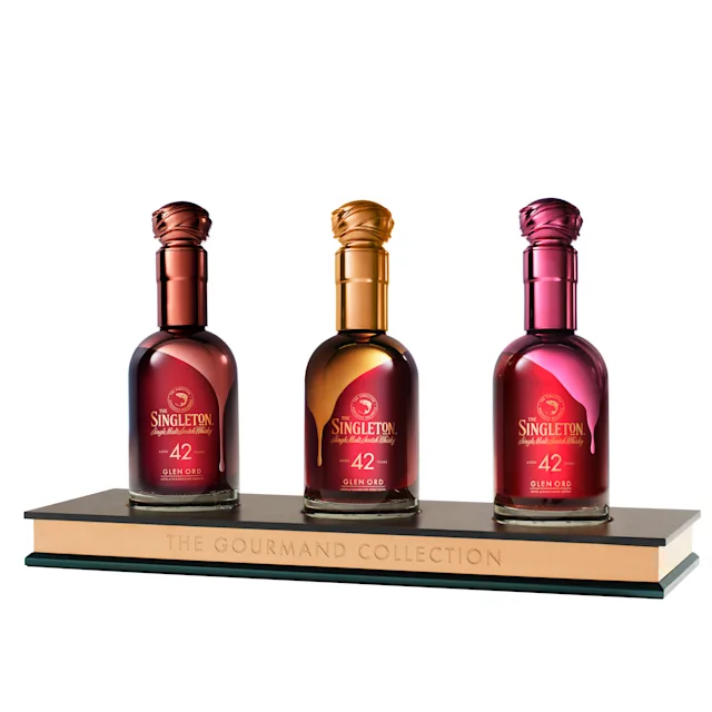 De Gourmand Collection van de Singleton drie whiskyflessen gepresenteerd op een sokkel