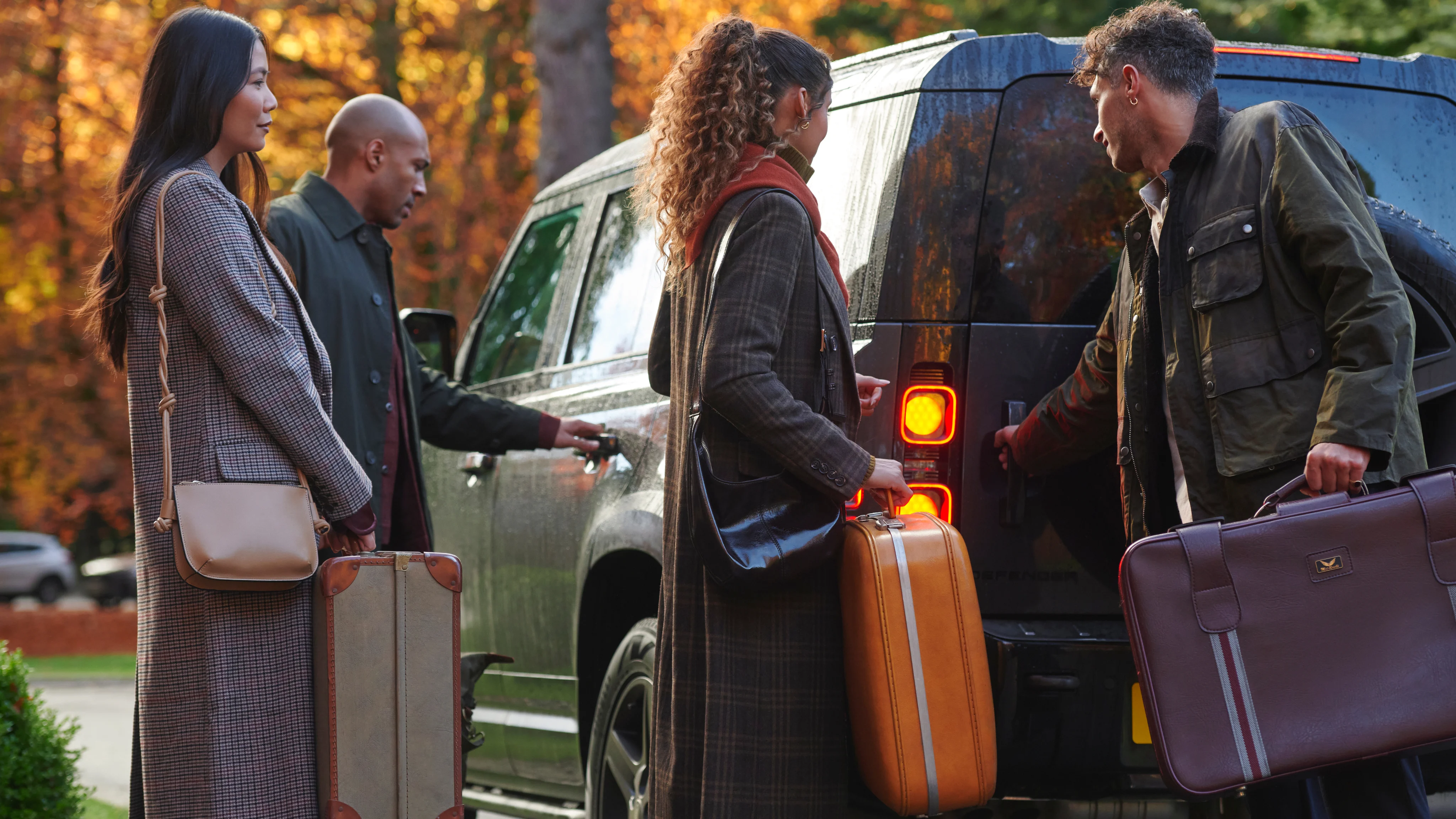 Group of travelers loading suitcases into a car before heading on a whisky trip.
