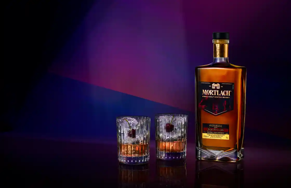 Mortlach Midnight Dusk bottle sitting next to two tumblers served on ice 