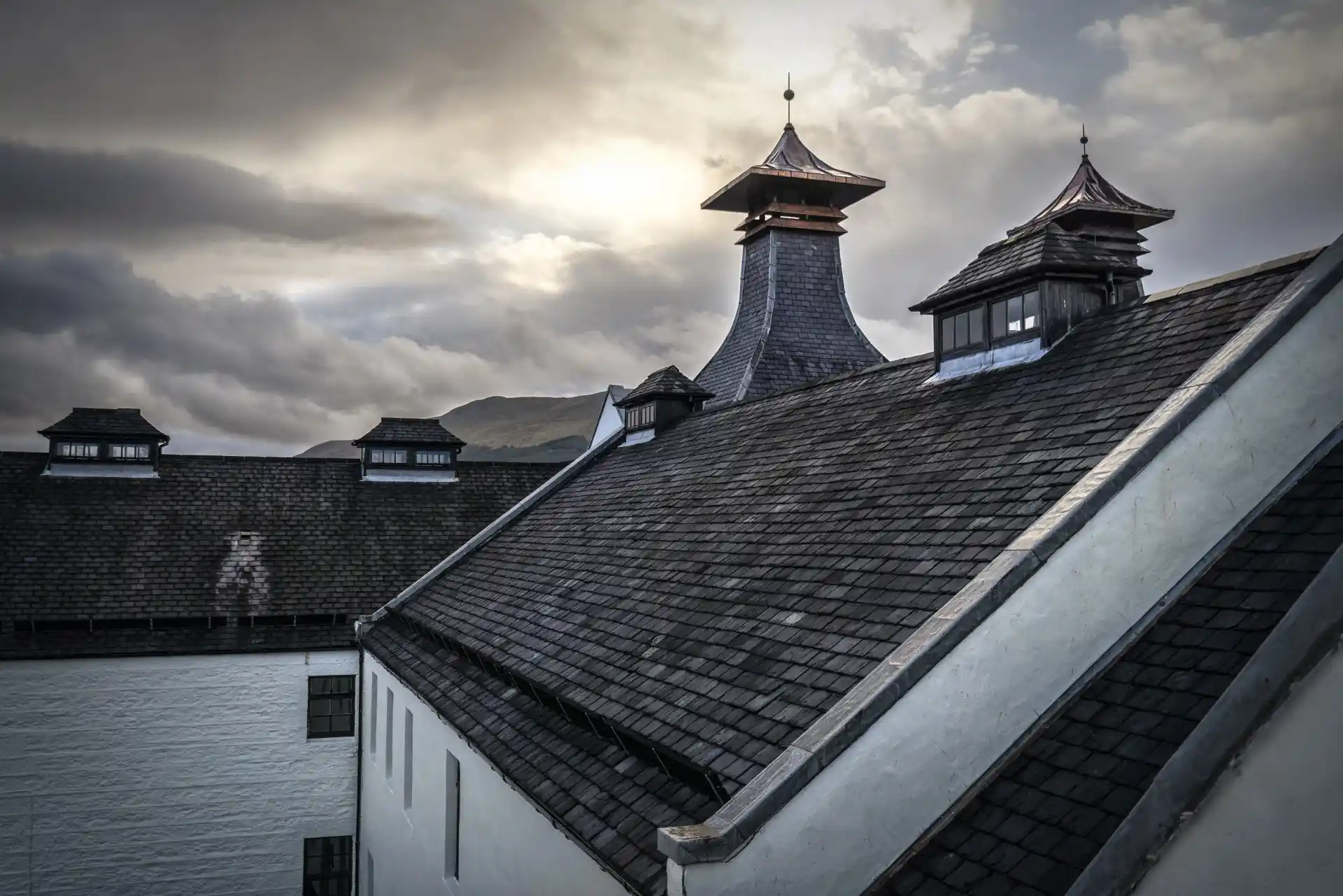 A white building with a grey slate pitched roof