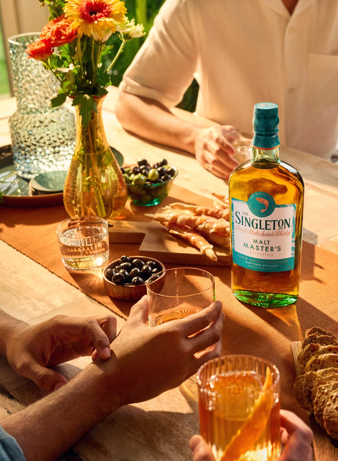 Friends around a table drinking The Singleton whisky.