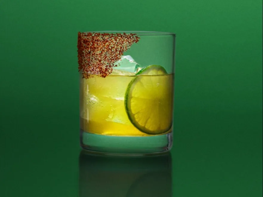 A spicy whisky margarita on a green background