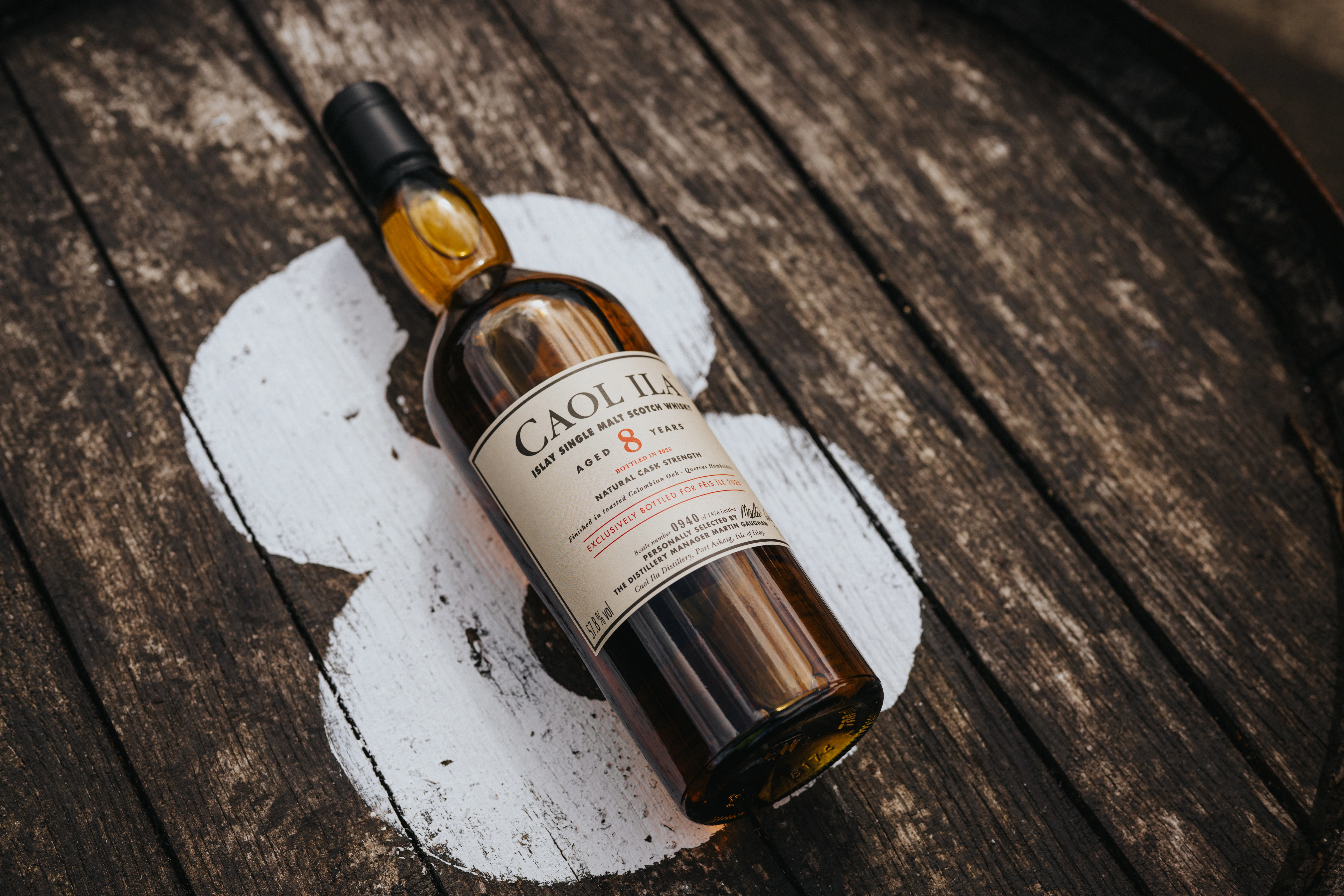 Die Flasche Caol Ila 8 Year Old Fèis Ìle 2025 Edition liegt auf einem Holzfass, das mit einer weißen Zahl 8 bemalt ist.