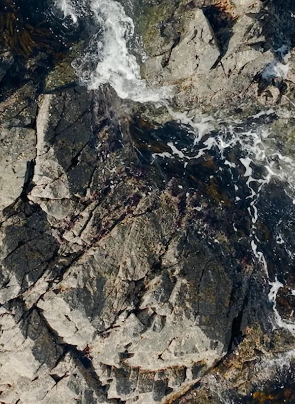 Oceaangolven die zachtjes tegen ruige rotsen slaan