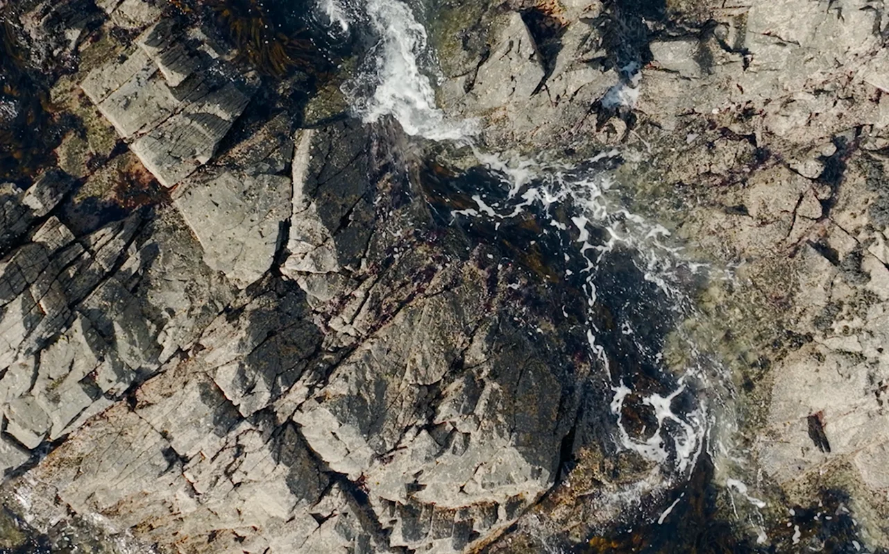 Ocean waves gently crashing against rugged rocks