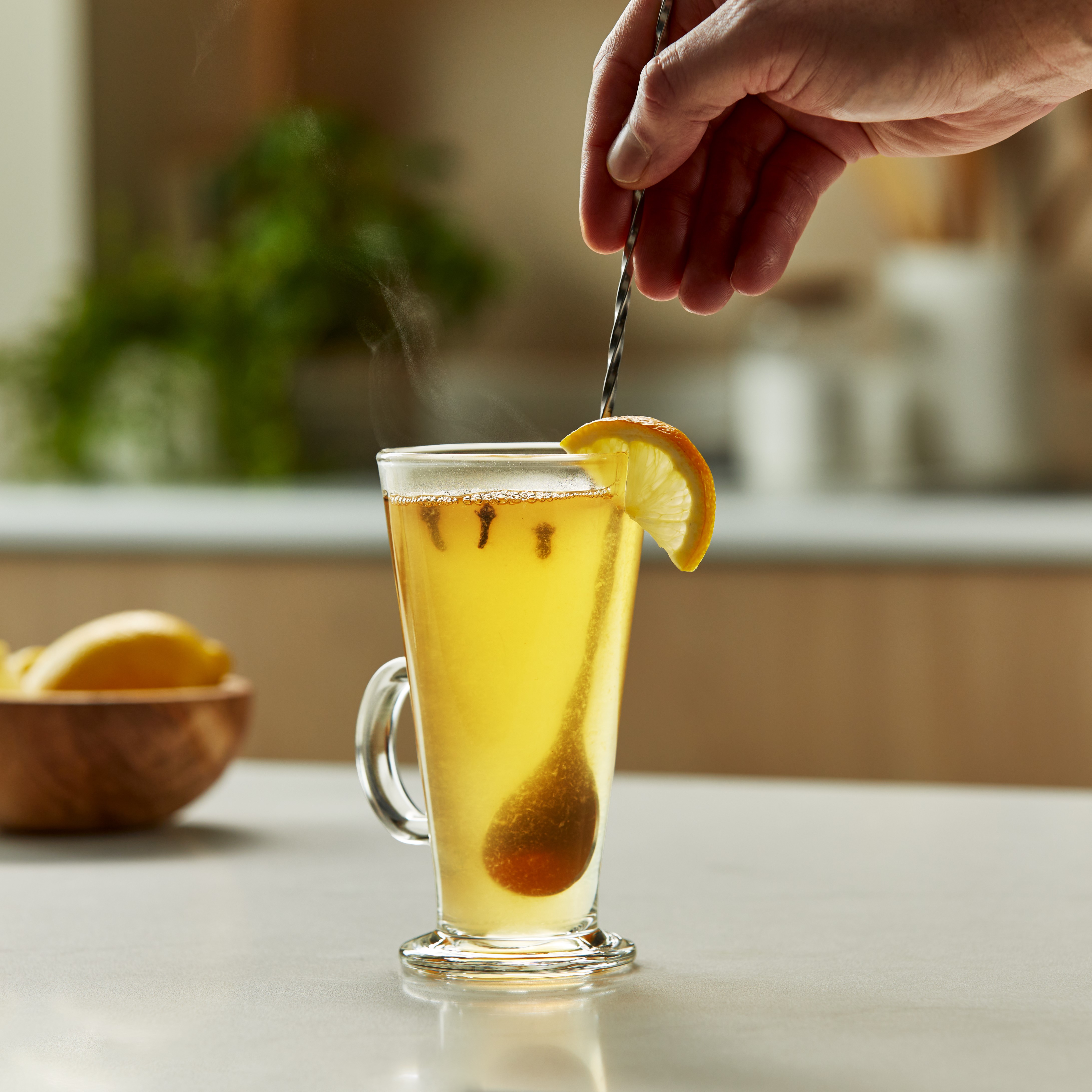 stirring a hot toddy cocktail with a bar spoon