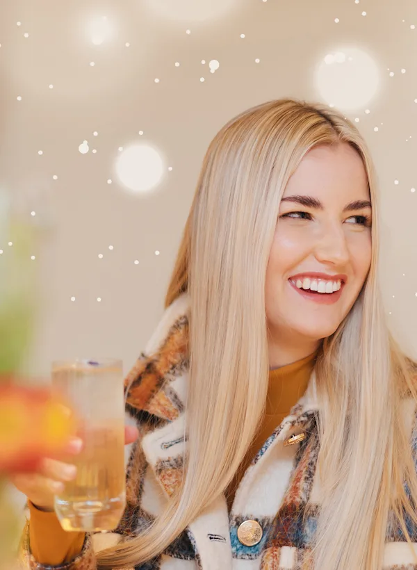 Blonde woman smiling and holding a delicious Glenkinchie cocktail