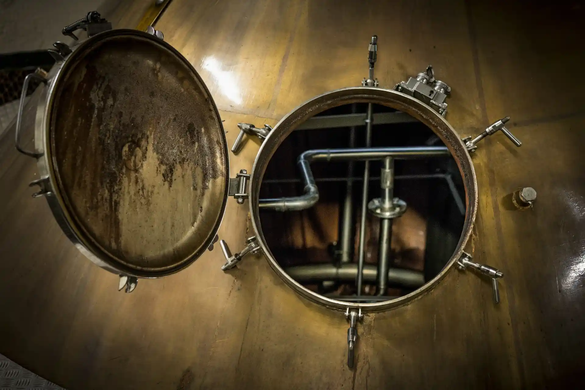 The inside of a whisky still is shown through its open hatch