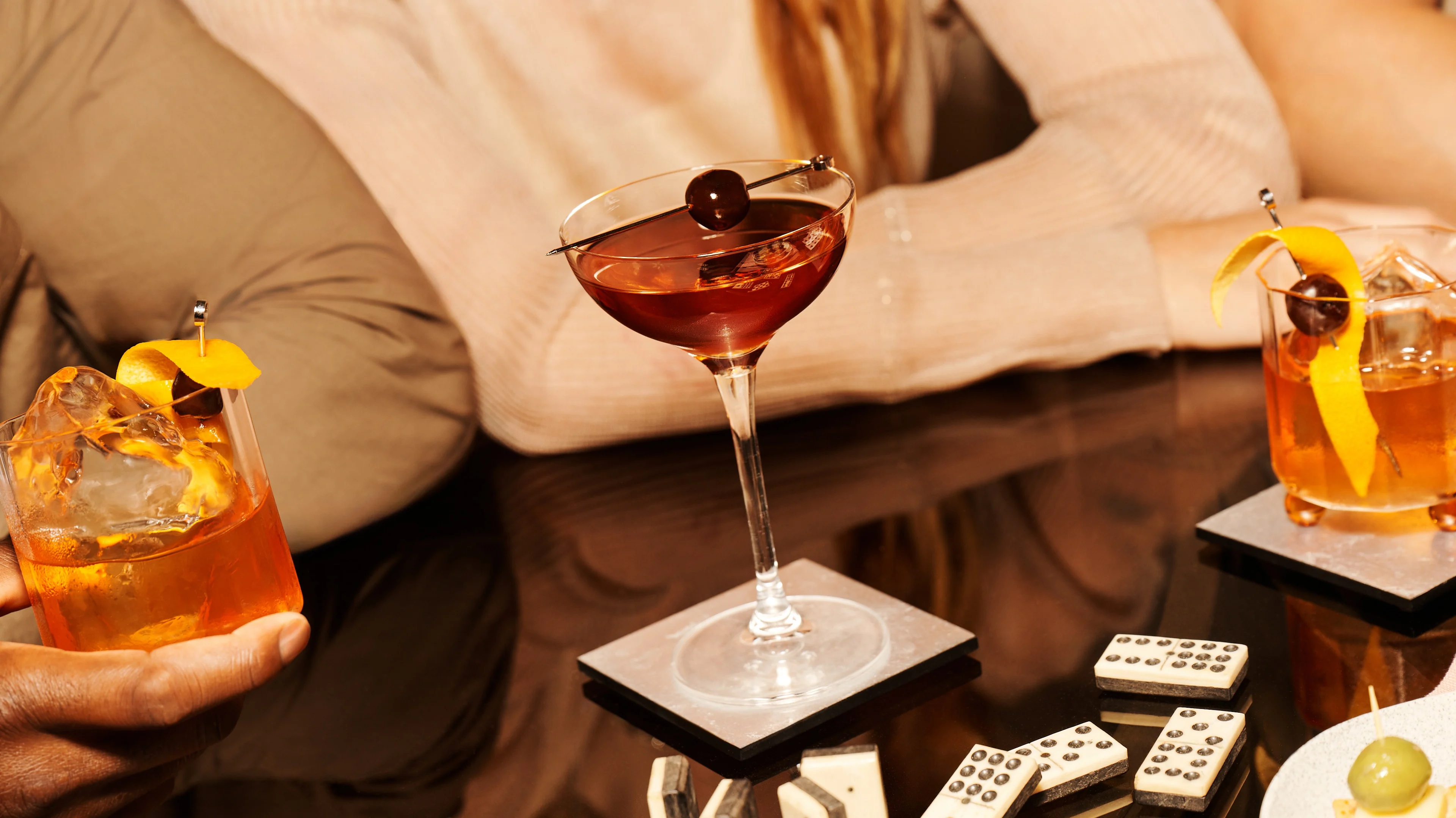 A cocktail in a coupe glass at a lively party.