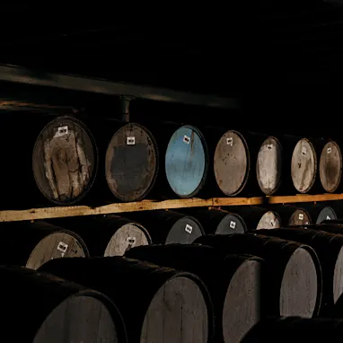 Several wooden barrels are stacked on top of each other in a barrel store.